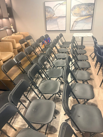 Row of gray folding chairs in a room.